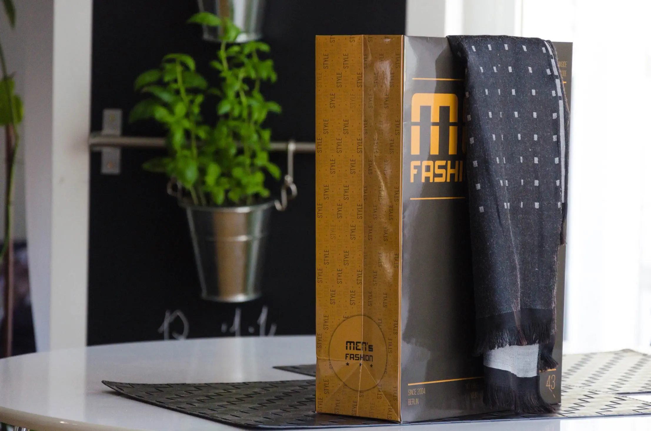 Schwarze orange Papiertragetasche auf weißen Tisch Schwarze orange Papiertragetasche auf weißen Tisch