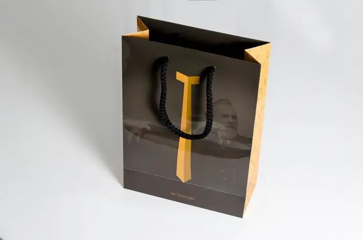 Schwarze orange Papiertragetasche auf weißen Hintergrund